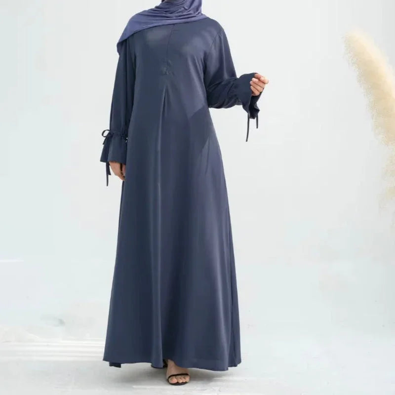 a model wearing a navy blue nursing friendly abaya with a matching navy blue hijab