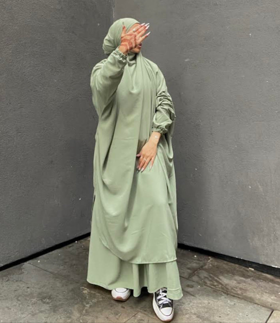 a women wearing a sage pastel green two piece jilbab