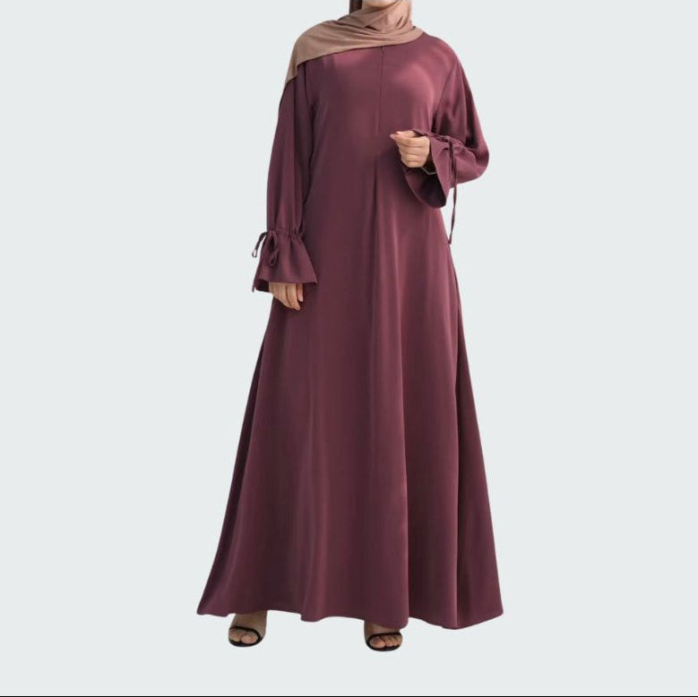 a women wearing a plum nursing friendly abaya with ruffle sleeves and front zip